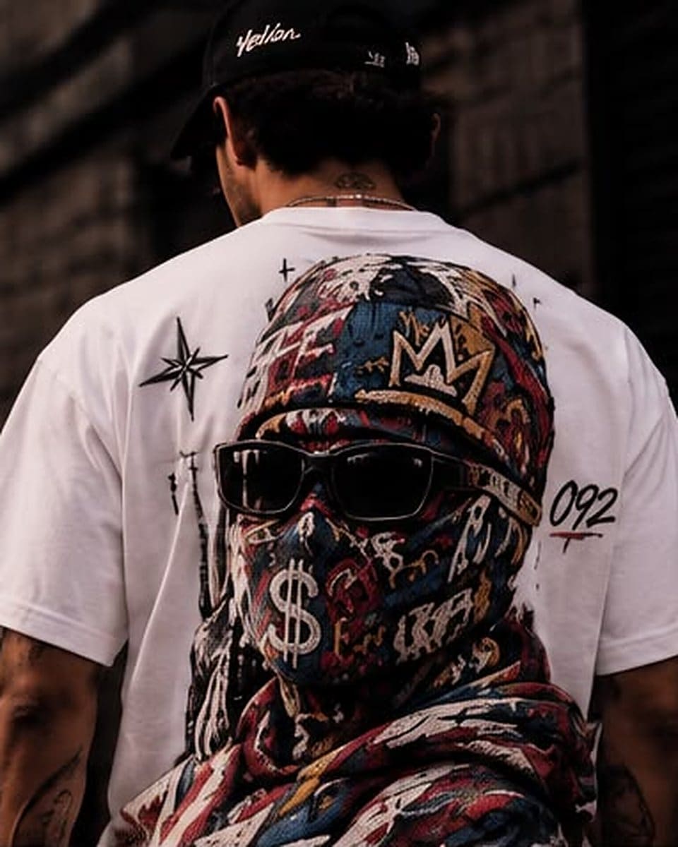 Camiseta oversize blanco, espalda: un encapuchado de grafiti con corona y signo de pesos, una estrella y el 092