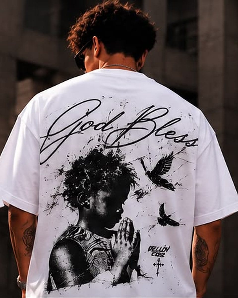 Camiseta oversize blanco, espalda: «God Bless» en caligrafía, un niño rezando y palomas en tinta negra
